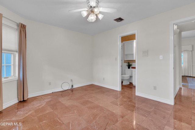 unfurnished room with visible vents, marble finish floor, ceiling fan, and baseboards