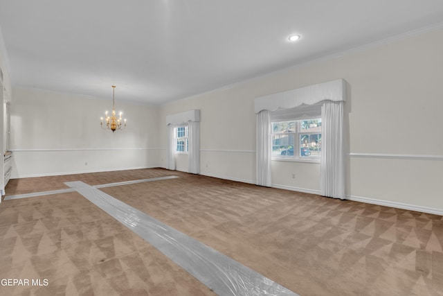 carpeted empty room featuring an inviting chandelier, baseboards, and ornamental molding