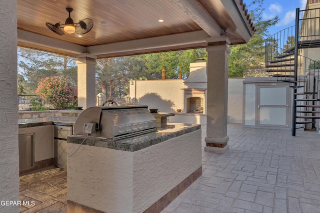view of patio / terrace with stairway, exterior fireplace, and area for grilling