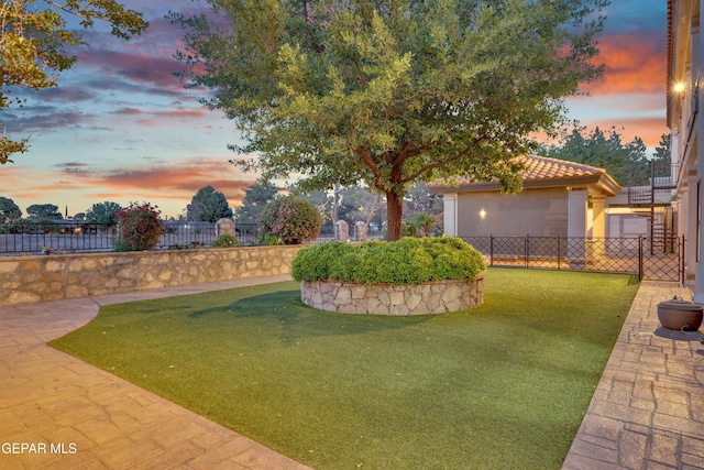 yard at dusk featuring fence