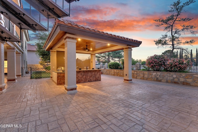 view of patio / terrace featuring a gazebo, ceiling fan, fence, and exterior bar