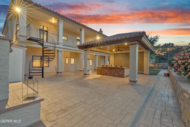 exterior space with fence, outdoor dry bar, area for grilling, and stairway