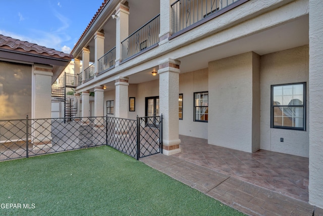 view of patio / terrace with fence, stairs, and a balcony