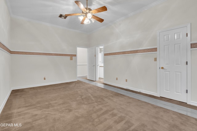empty room with crown molding, a ceiling fan, baseboards, and visible vents