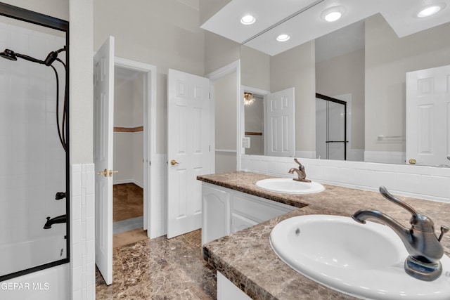 bathroom with double vanity, a sink, marble finish floor, and a stall shower