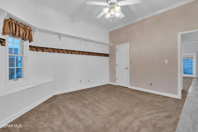 spare room featuring carpet floors, ceiling fan, ornamental molding, and baseboards
