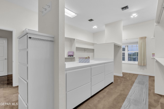 walk in closet with visible vents and light colored carpet