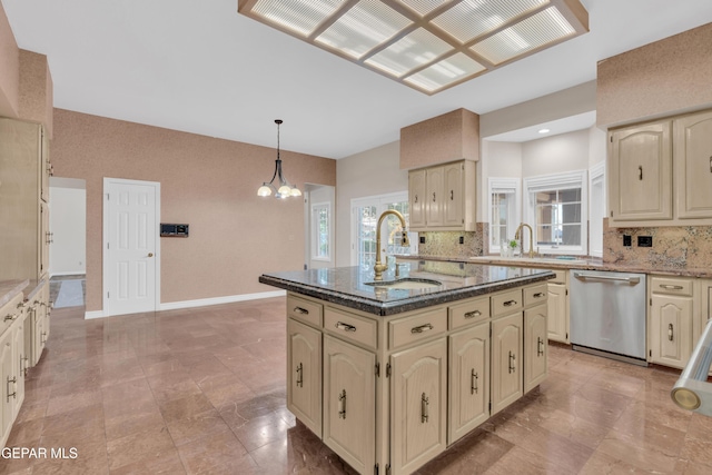 kitchen with stainless steel dishwasher, backsplash, a sink, and cream cabinets