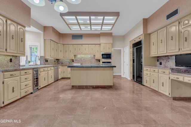 kitchen with visible vents, decorative backsplash, built in appliances, and cream cabinets