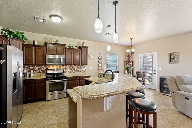 kitchen featuring a textured ceiling, stainless steel appliances, and a sink
