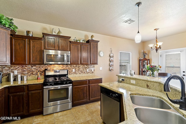 kitchen featuring a sink, an inviting chandelier, stainless steel appliances, backsplash, and visible vents