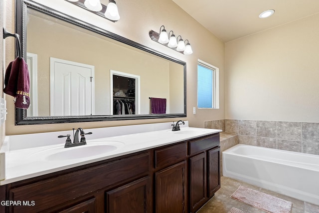 bathroom featuring a bath, tile patterned floors, a sink, and double vanity