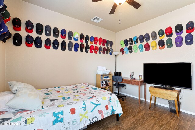 bedroom featuring wood finished floors, visible vents, a ceiling fan, and baseboards