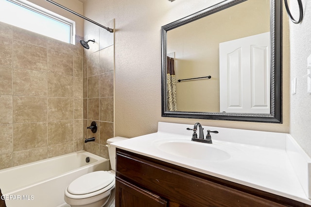 full bathroom featuring toilet, a textured wall, vanity, and shower / tub combination