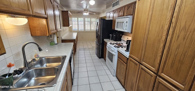 2704 Gaston Dr, El Paso, TX 79935 - kitchen with a sink, light tile patterned floors, visible vents, tile countertops, and white appliances