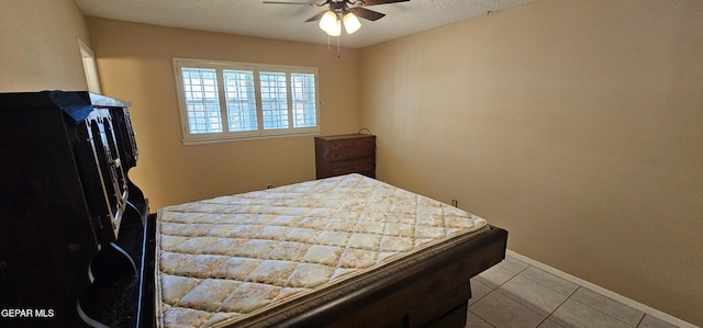 2704 Gaston Dr, El Paso, TX 79935 - bedroom featuring light tile patterned floors, a textured ceiling, a ceiling fan, and baseboards