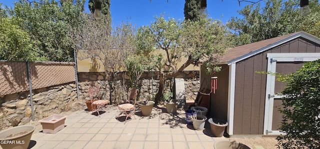 2704 Gaston Dr, El Paso, TX 79935 - view of patio featuring an outbuilding, a storage unit, and fence