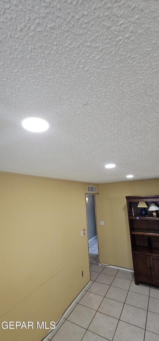 2704 Gaston Dr, El Paso, TX 79935 - unfurnished room with light tile patterned flooring and a textured ceiling