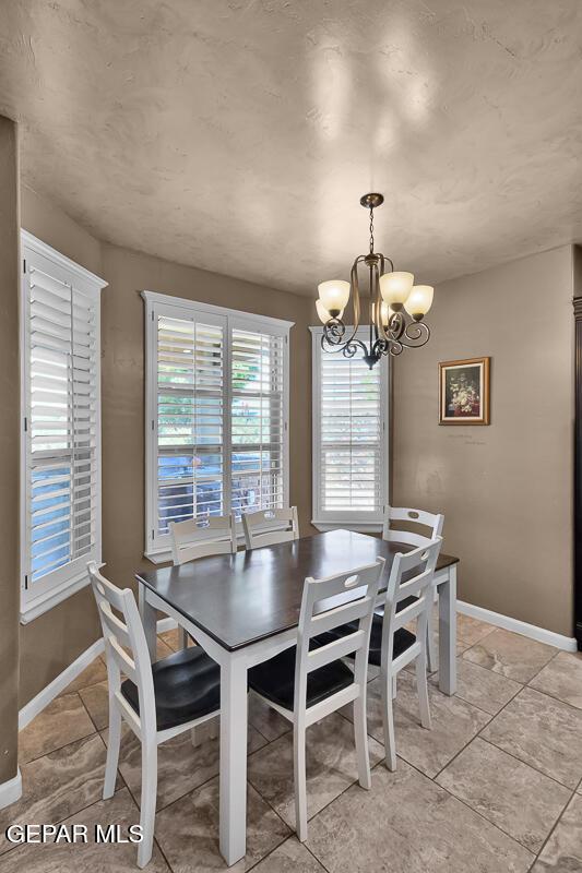 7229 Camino Del Sol Dr, El Paso, TX 79911 - dining room featuring a chandelier, baseboards, and light tile patterned floors