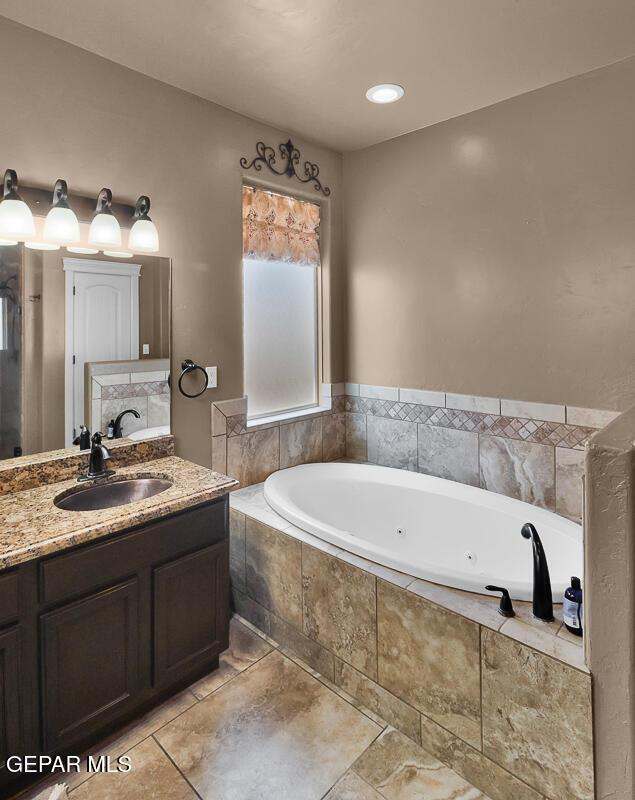 7229 Camino Del Sol Dr, El Paso, TX 79911 - bathroom featuring a tub with jets, vanity, and tile patterned floors