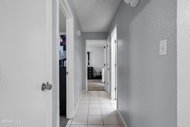 1808 Loanda Ln, El Paso, TX 79928 - corridor with light tile patterned flooring, a textured ceiling, baseboards, and light colored carpet