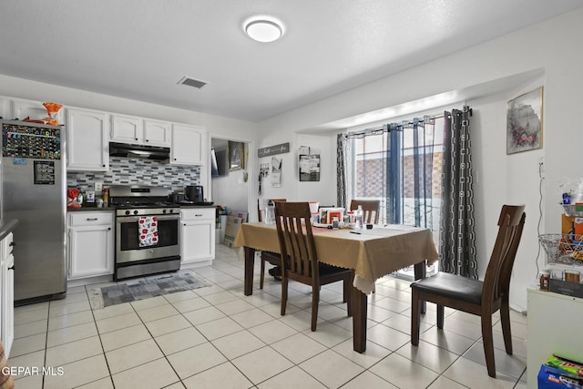 1808 Loanda Ln, El Paso, TX 79928 - kitchen with under cabinet range hood, dark countertops, appliances with stainless steel finishes, and white cabinets