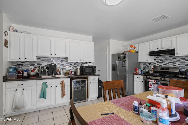 1808 Loanda Ln, El Paso, TX 79928 - kitchen featuring stainless steel appliances, visible vents, decorative backsplash, under cabinet range hood, and beverage cooler