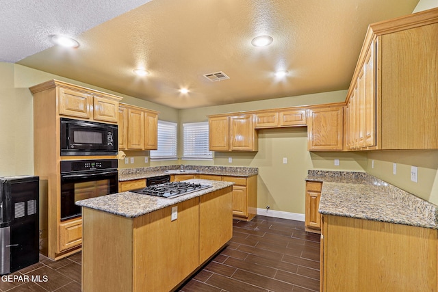 kitchen featuring visible vents, light stone countertops, recessed lighting, a textured ceiling, and black appliances