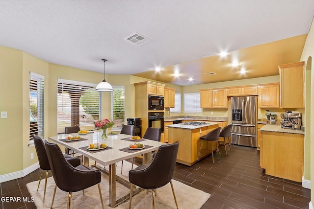 dining room featuring baseboards, visible vents, and wood tiled floor