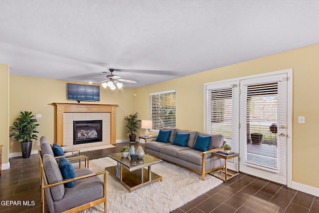 living room featuring baseboards, a ceiling fan, wood finish floors, and a wealth of natural light