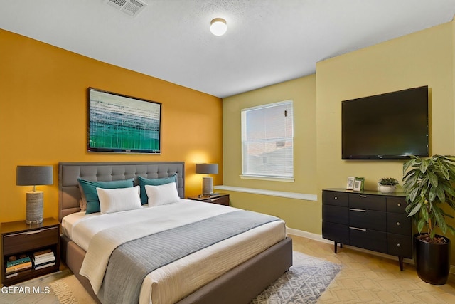 bedroom with baseboards and visible vents