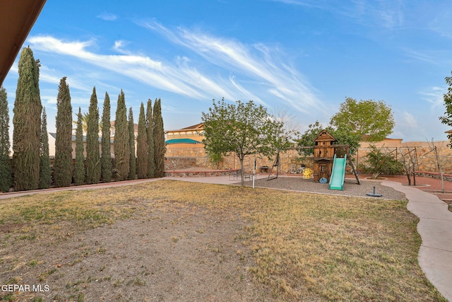 view of yard featuring fence and a playground
