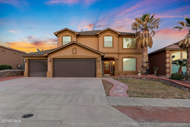 view of front facade with a garage, stucco siding, and driveway