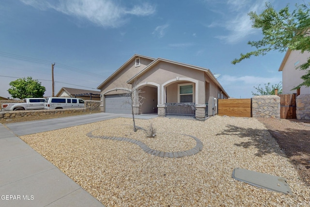 ranch-style home featuring a gate, fence, concrete driveway, an attached garage, and stucco siding