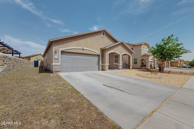 view of front of property with stucco siding, driveway, and a garage