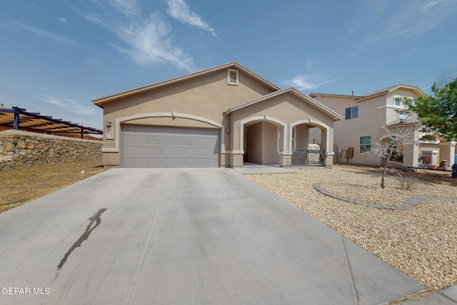 mediterranean / spanish house with stucco siding, fence, concrete driveway, and a garage