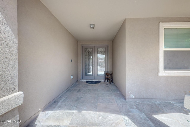 doorway to property featuring stucco siding and french doors