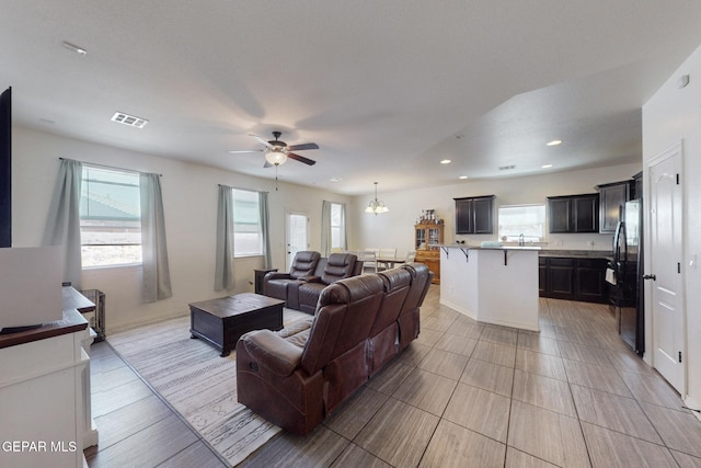 living room with a ceiling fan, visible vents, and recessed lighting