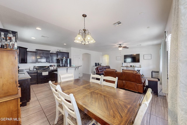 dining space featuring ceiling fan with notable chandelier, visible vents, arched walkways, and recessed lighting
