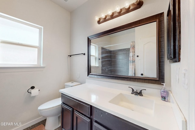bathroom featuring toilet, vanity, curtained shower, and baseboards