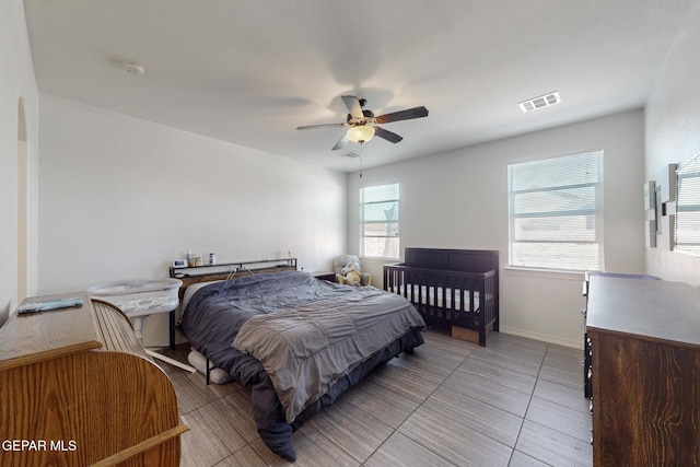 bedroom featuring baseboards, visible vents, ceiling fan, and light tile patterned flooring