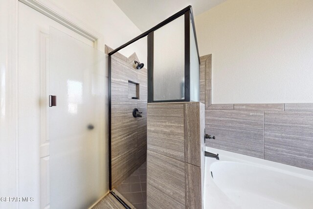 bathroom featuring a garden tub and a stall shower