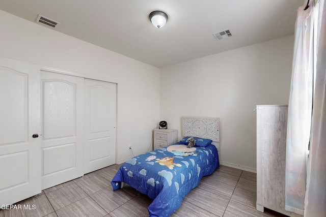 tiled bedroom with visible vents and a closet