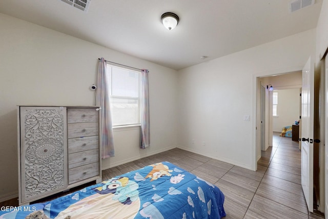 bedroom with baseboards, tile patterned floors, and visible vents
