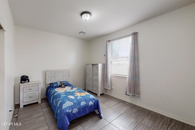 bedroom with baseboards and visible vents