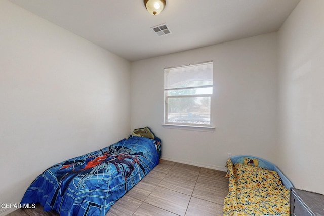 tiled bedroom with baseboards and visible vents