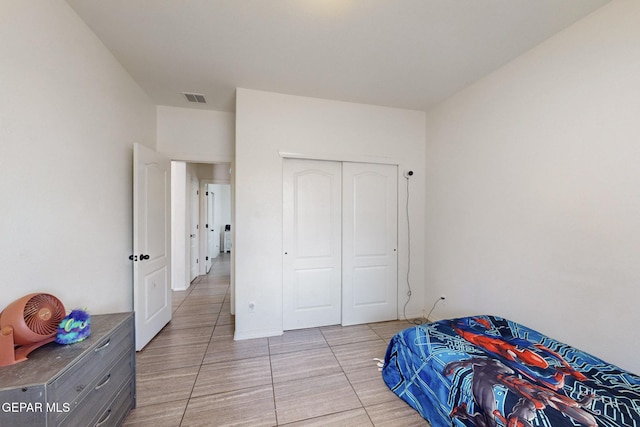 bedroom featuring a closet, visible vents, and light tile patterned floors