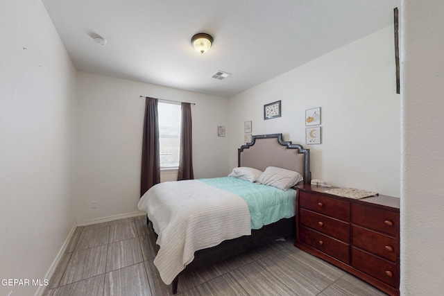 bedroom featuring baseboards and visible vents
