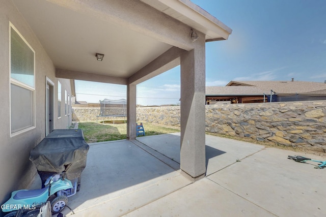 view of patio / terrace with a fenced backyard, a trampoline, and area for grilling