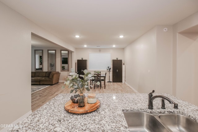 10716 Drew Pearson Dr, El Paso, TX 79924 - kitchen featuring recessed lighting, wood finished floors, a sink, light stone countertops, and baseboards